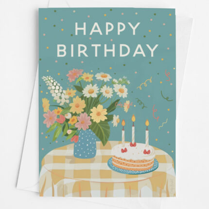 Birthday greeting card, design features a cheerful bouquet of flowers and birthday cake, on top of a yellow plaid covered table.