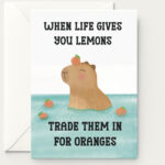 Encouragement greeting card featuring a capybara in water surrounded by oranges. The text says when life gives you lemons, treat them in for oranges.